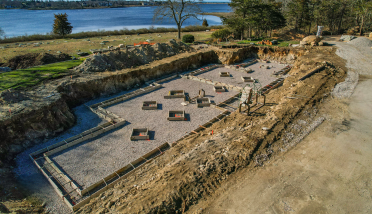 An aerial view of a construction site next to a body of water.