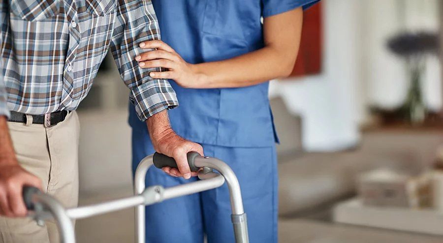 A Nurse Is Helping an Elderly Man Use a Walker — Wonder Care Australia Pty Ltd in Kearneys Spring, QLD
