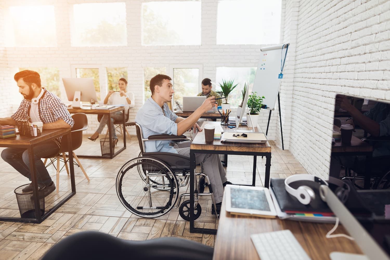 A Man in A Wheelchair Is Sitting at A Desk in An Office — Wonder Care Australia Pty Ltd in Kearneys Spring, QLD