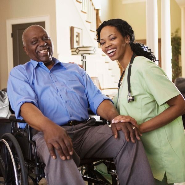 A Nurse Sits Next to A Man in A Wheelchair — Wonder Care Australia Pty Ltd in Kearneys Spring, QLD