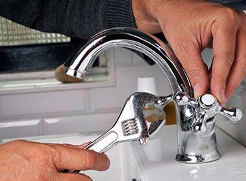 Plumbing — Plumber Fixing Faucet in Clinton, MO