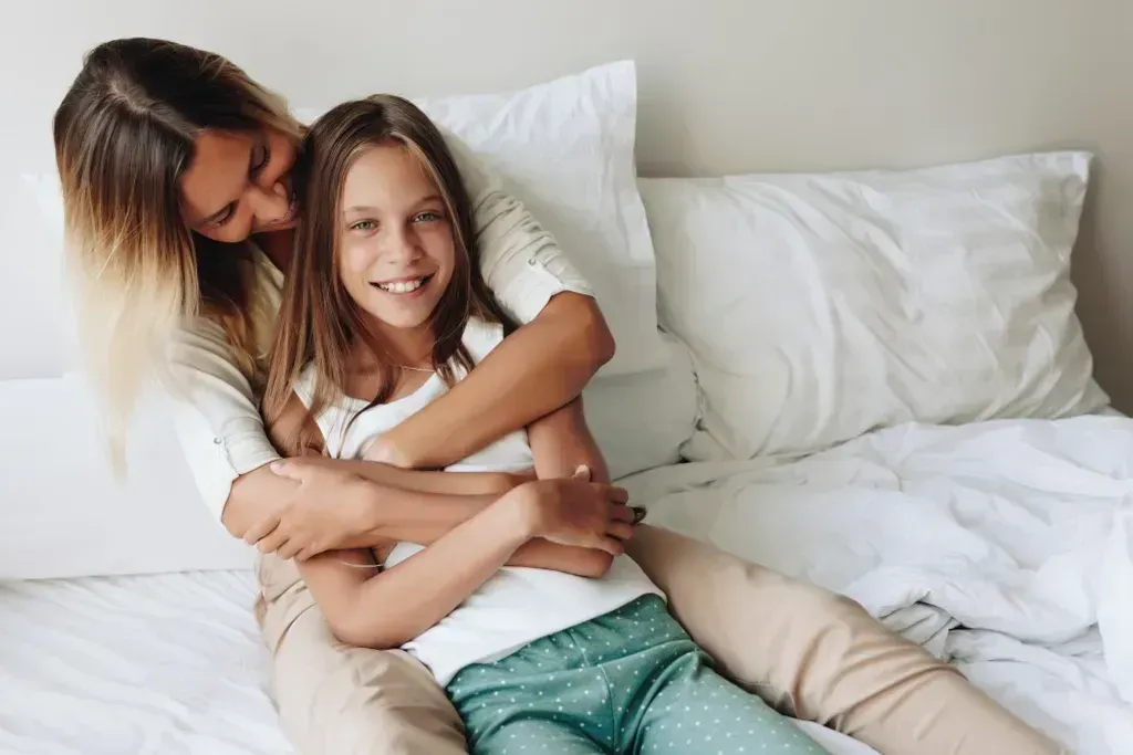 Young girl being hugged by her mother.