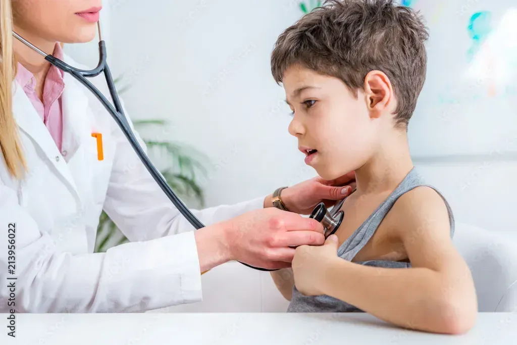 Doctor examining a young boy with a stethoscope.