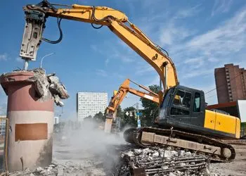 A bulldozer is demolishing a building with a hammer.
