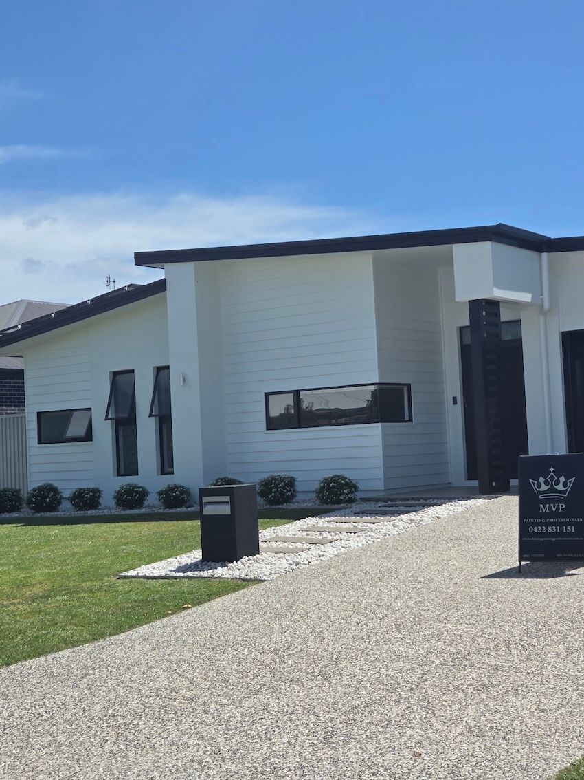 Modern white house with dark trim and a gravel driveway, on a sunny day— MVP Painting Professionals in Sunshine Coast, QLD
