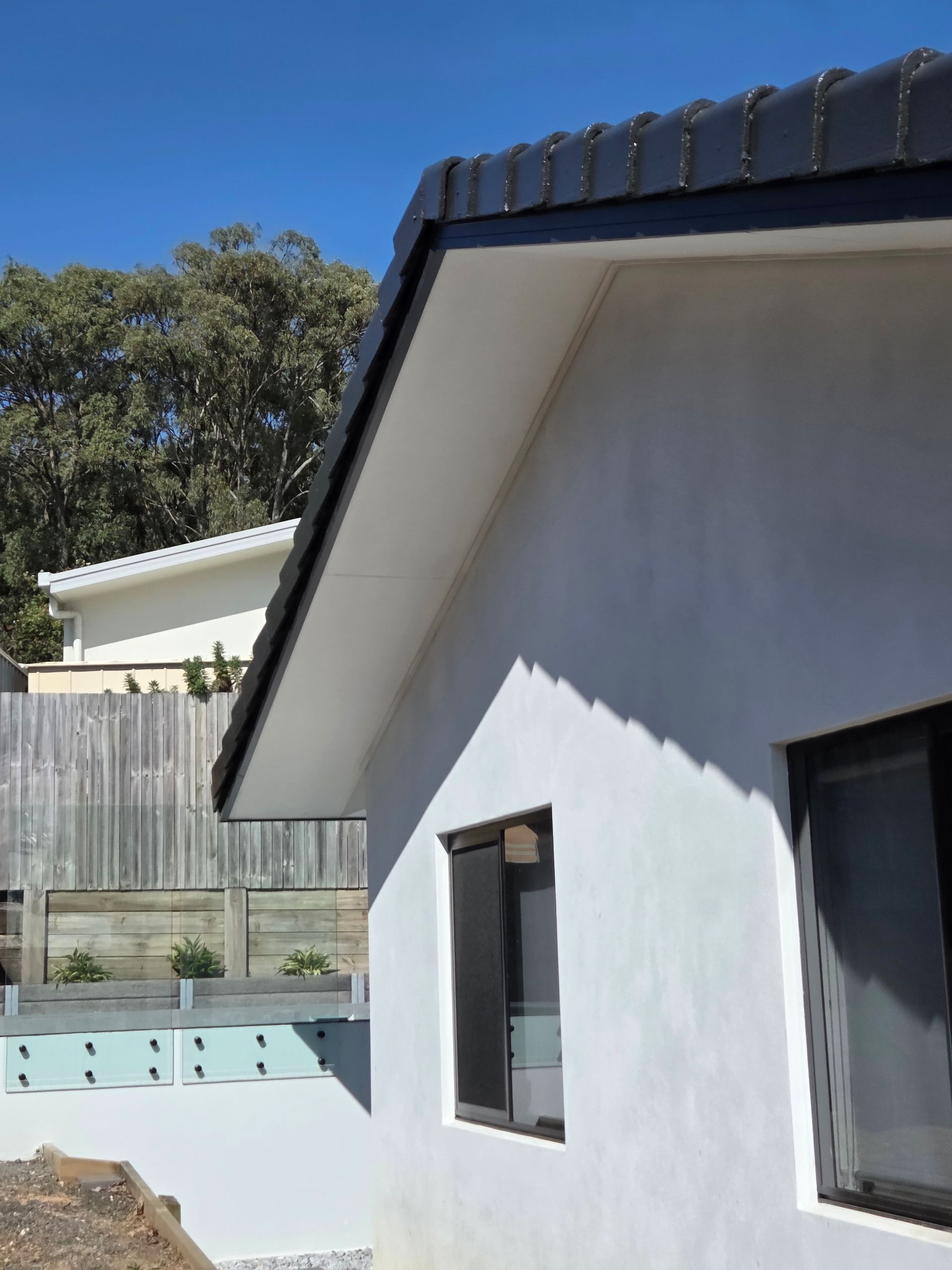White House Exterior With Dark Roof and Two Windows — MVP Painting Professionals in Sunshine Coast, QLD