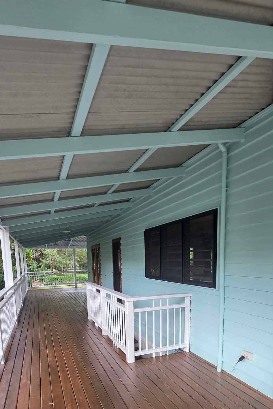 Covered porch with light blue walls, wooden floor, white railing — MVP Painting Professionals in Caloundra, QLD