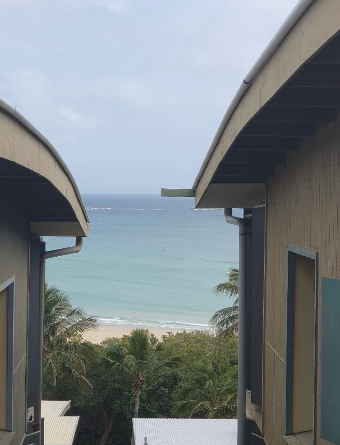 View of the ocean framed by two buildings — MVP Painting Professionals in Sunshine Coast, QLD
