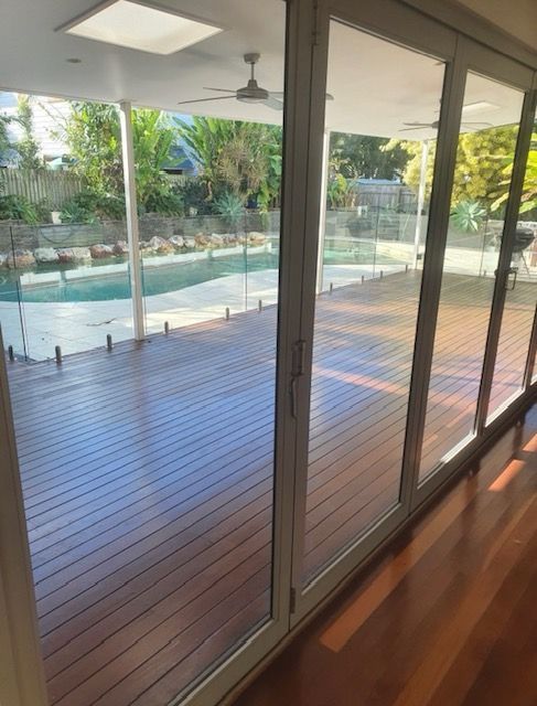Glass doors open onto a wooden deck overlooking a pool — MVP Painting Professionals in Maroochydore, QLD