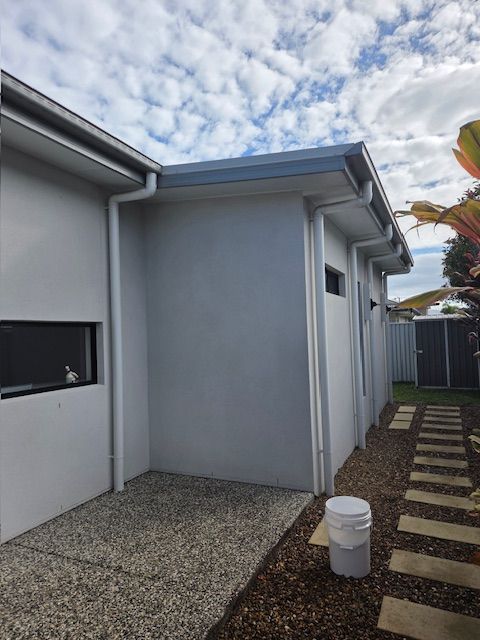 Exterior view of a light gray building with white gutters and a pathway — MVP Painting Professionals in Maroochydore, QLD