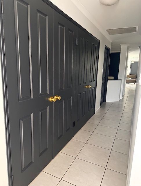 Dark grey closet doors with gold handles in a hallway — MVP Painting Professionals in Nambour, QLD