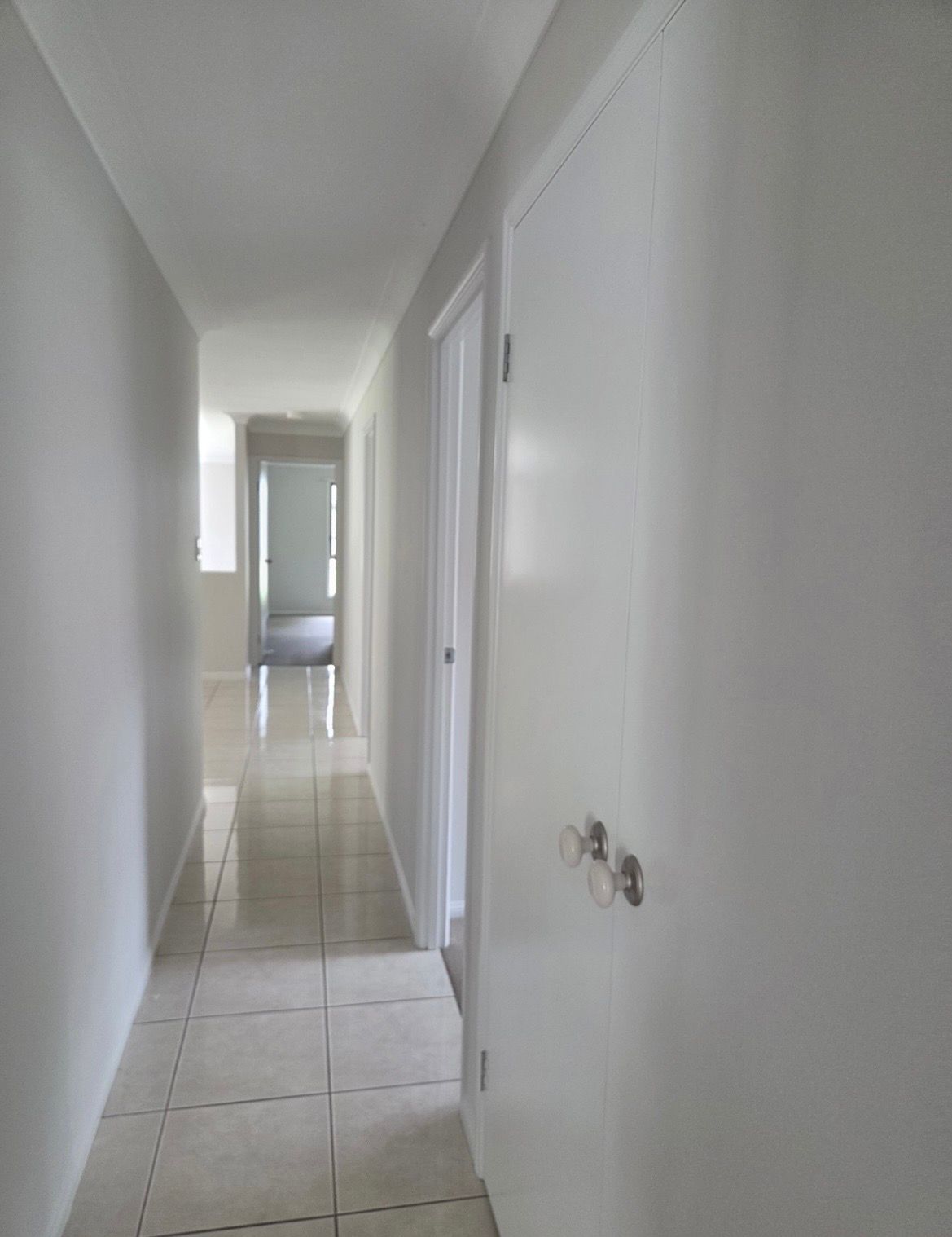 Narrow hallway with white walls, tiled floor, and doors — MVP Painting Professionals in Coolum, QLD