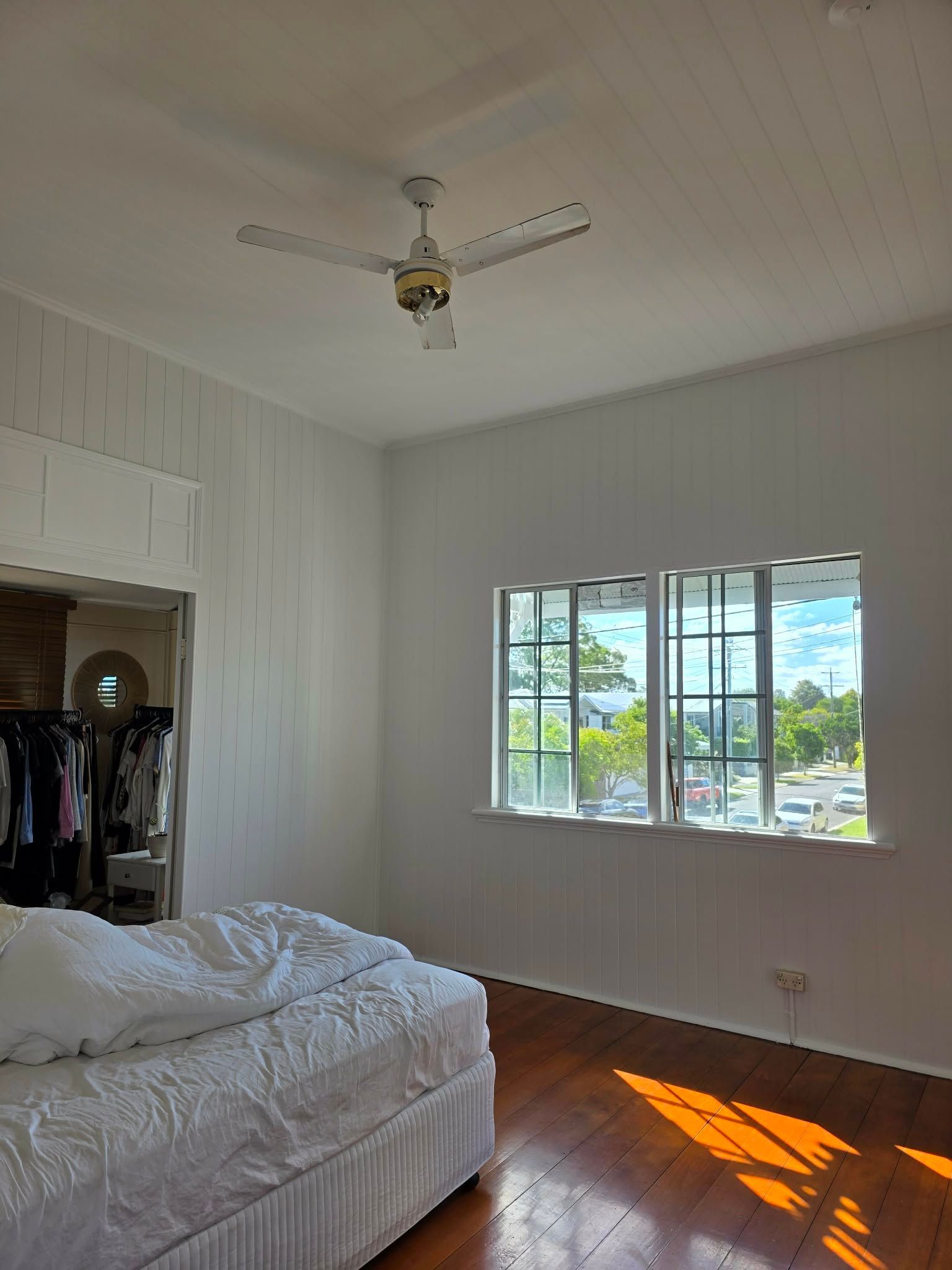 Bedroom with white walls, window, ceiling fan, bed, and wardrobe opening — MVP Painting Professionals in Sunshine Coast, QLD