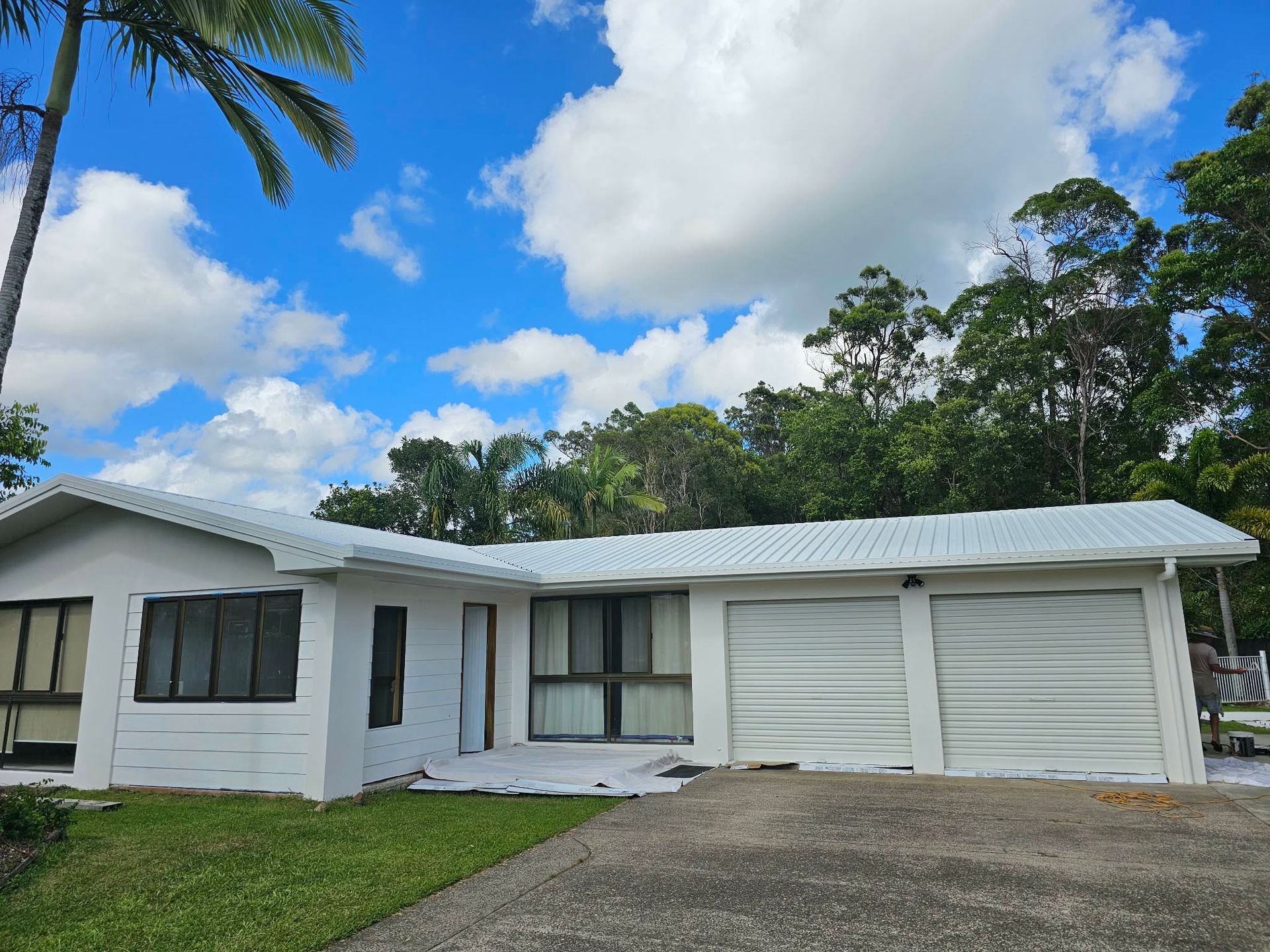 Man Painting a Black Fence, Standing in a Backyard — MVP Painting Professionals in Maroochydore, QLD