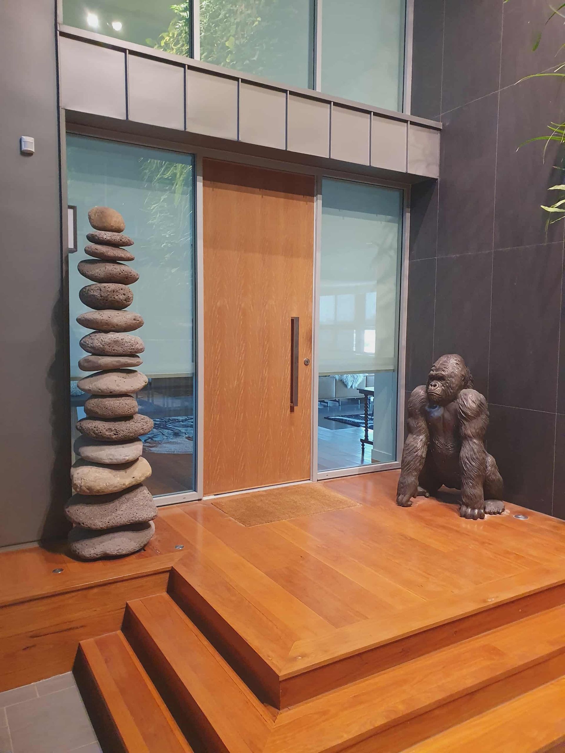 Wooden door entrance with stone stack and gorilla statue — MVP Painting Professionals in Sunshine Coast, QLD