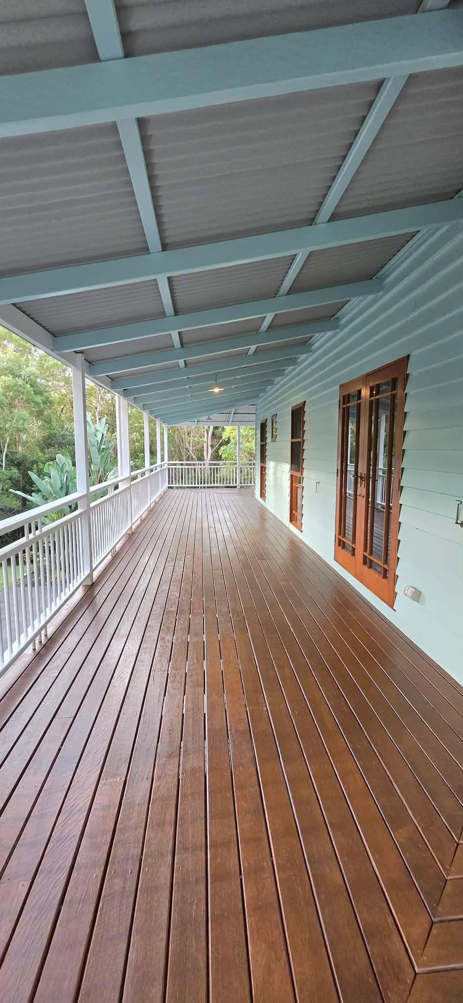 Wooden porch of a house with a gray corrugated roof, blue trim and doors— MVP Painting Professionals in Sunshine Coast, QLD