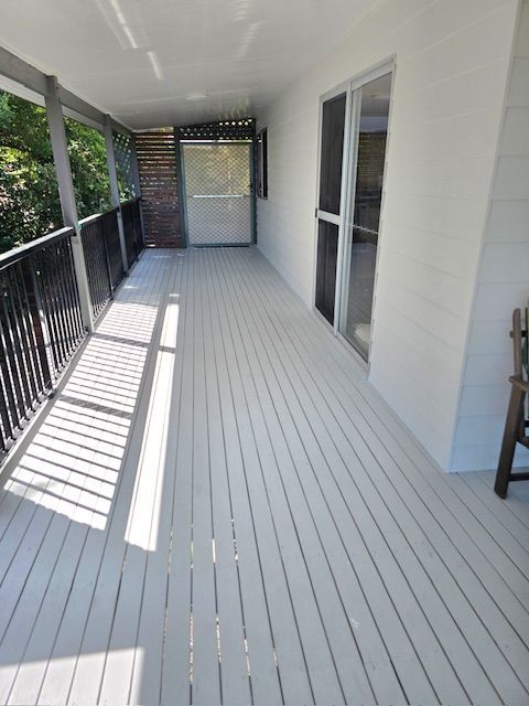 A Long Covered Wooden Deck With Light Gray Paint — MVP Painting Professionals in Sunshine Coast, QLD