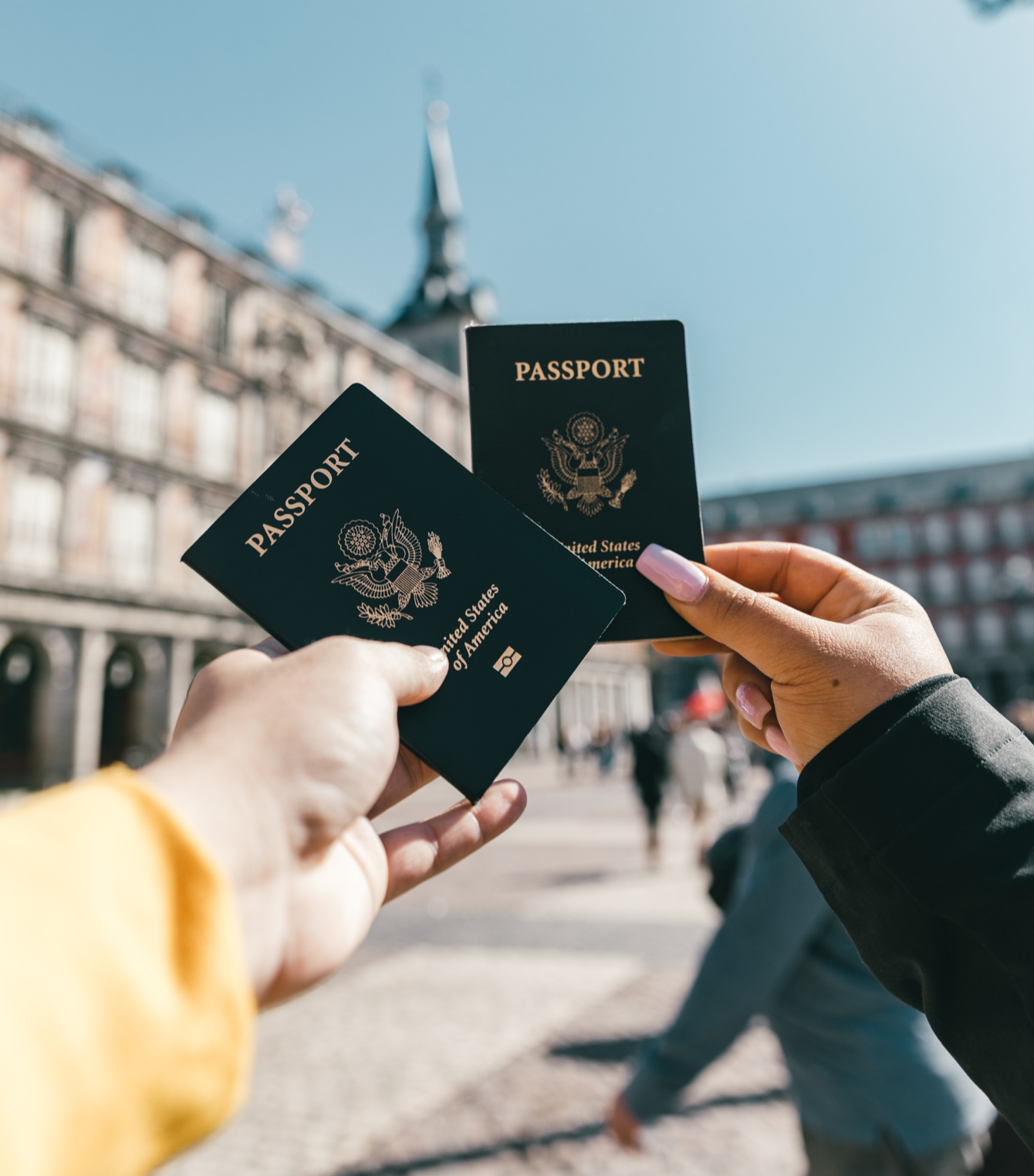 A person is holding two passports in their hands