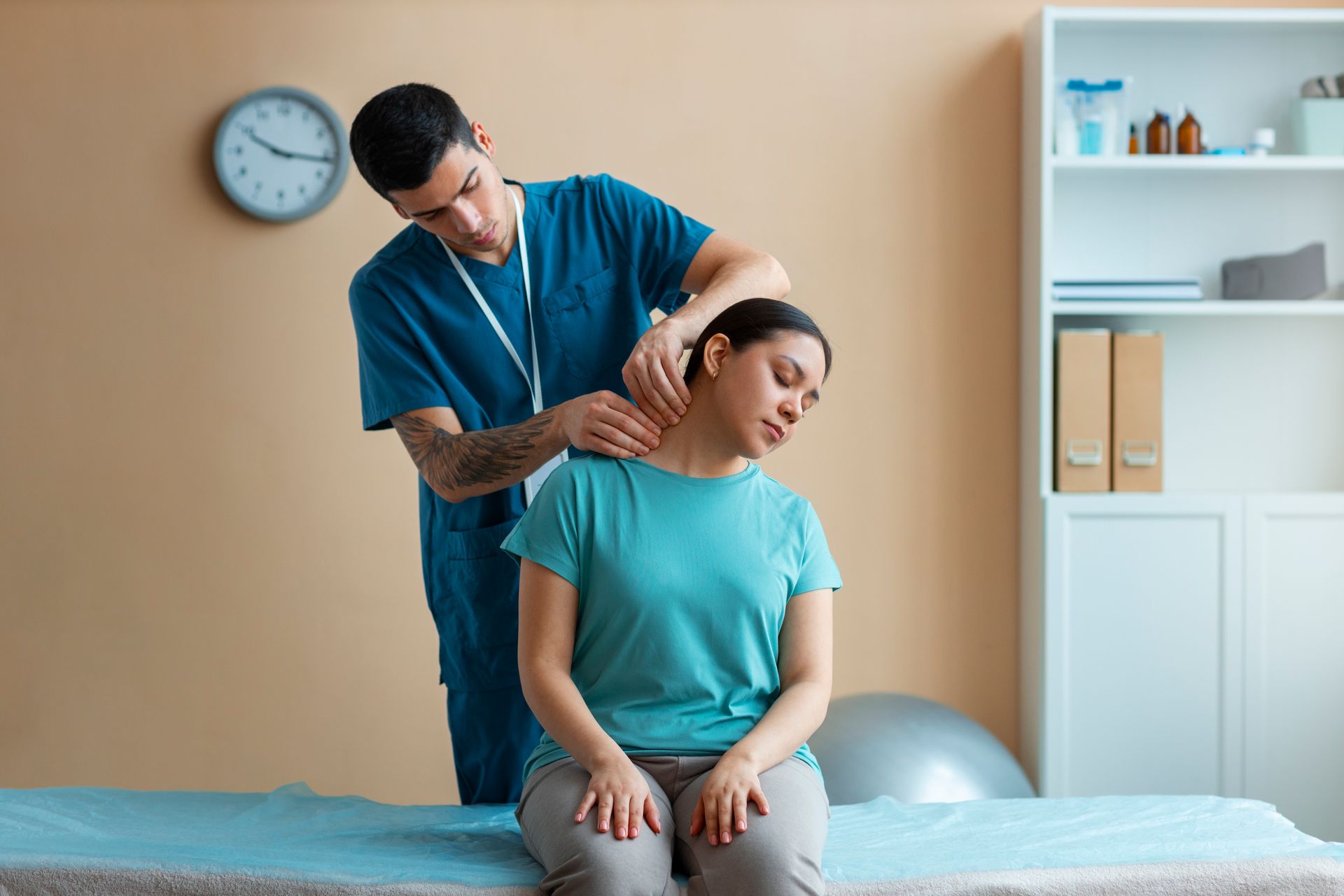Physical therapist assisting a seated patient with a neck stretch in a clinic room