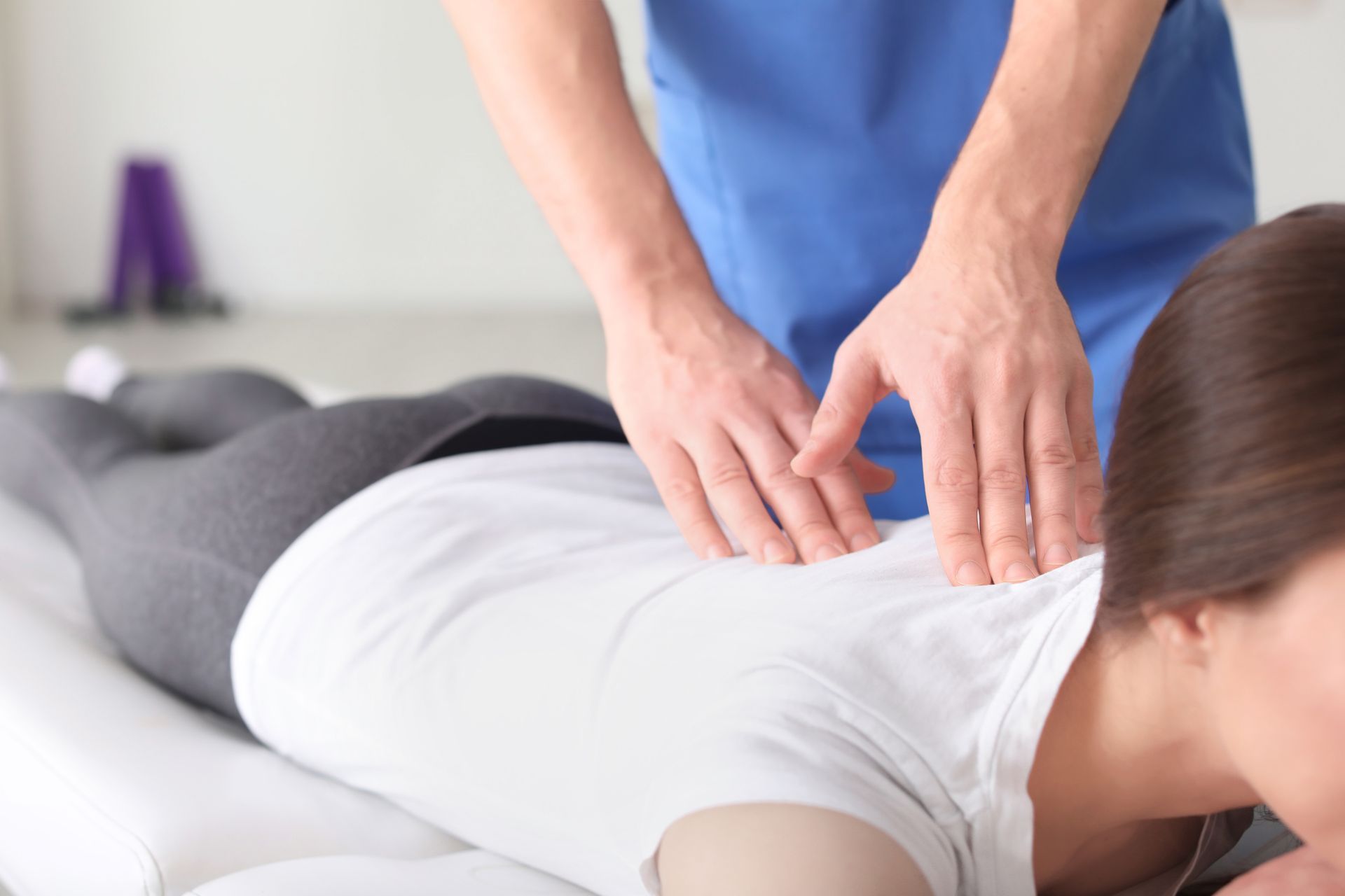 A person receiving a back massage from a healthcare professional in a clinic setting.