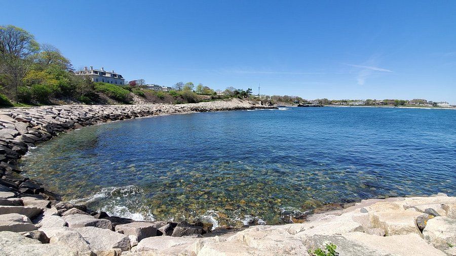 A large body of water surrounded by rocks on a sunny day.