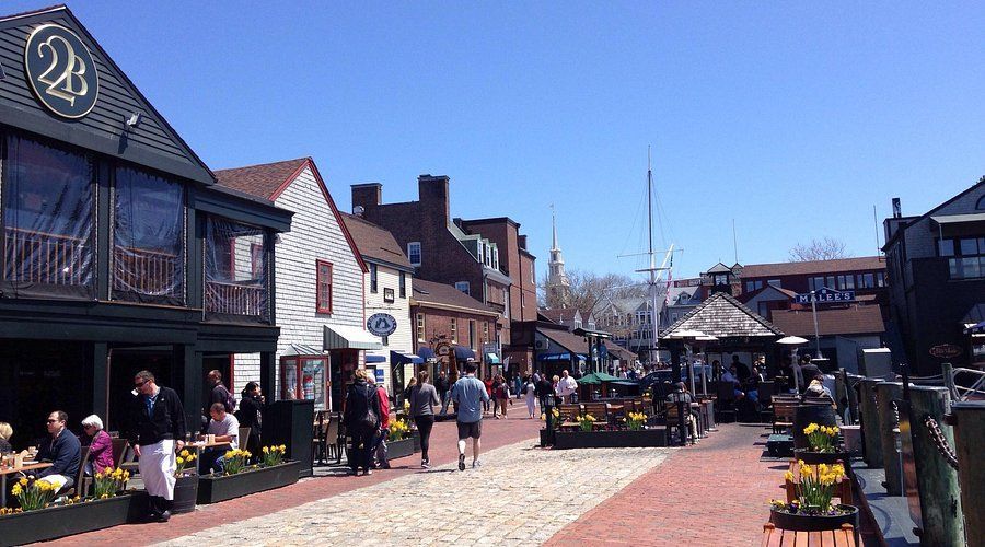 A group of people are walking down a cobblestone street in a city.