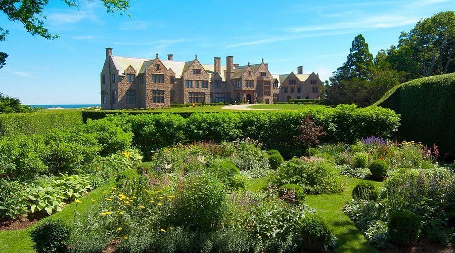 A large house is surrounded by a lush green garden.