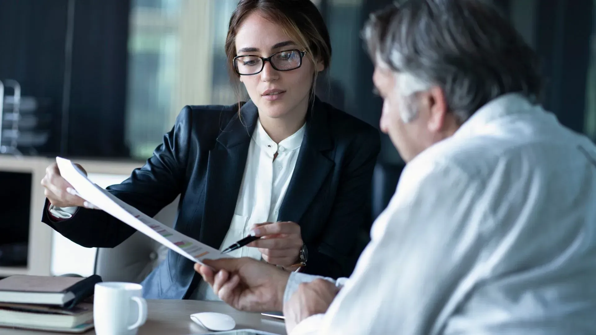 Female lawyer explaining legal documents to a male client during a consultation.
