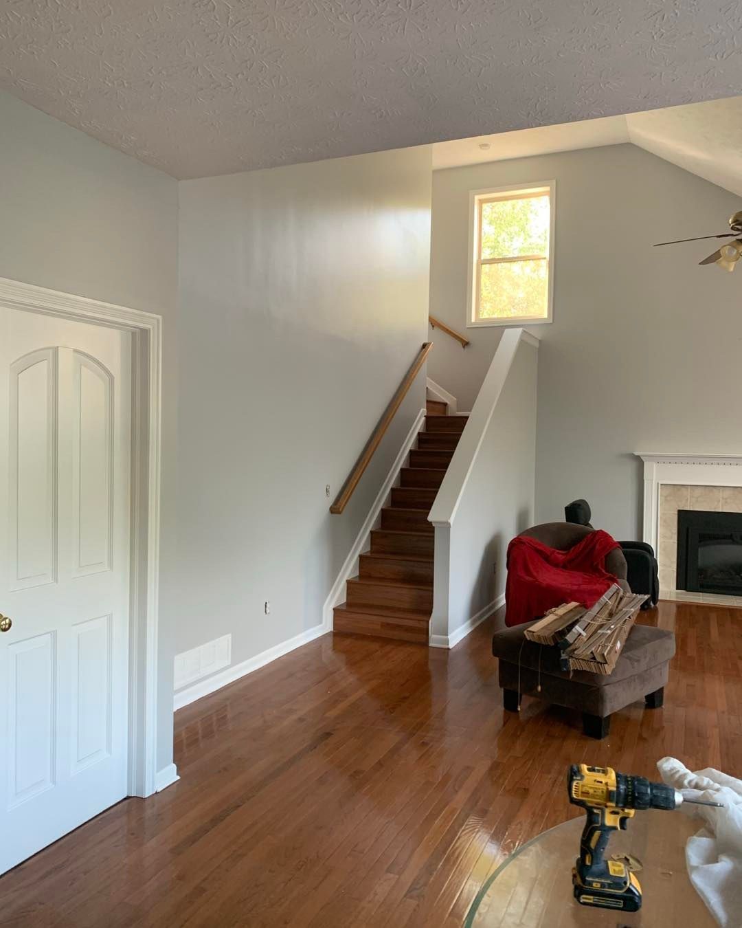 A person holding a baby up in the air indoors near a window, baby smiling.