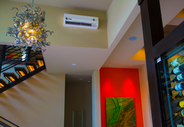 A room with a staircase and a painting on the wall