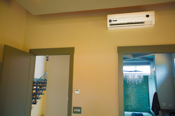 A room with a wall mounted air conditioner between two doors.