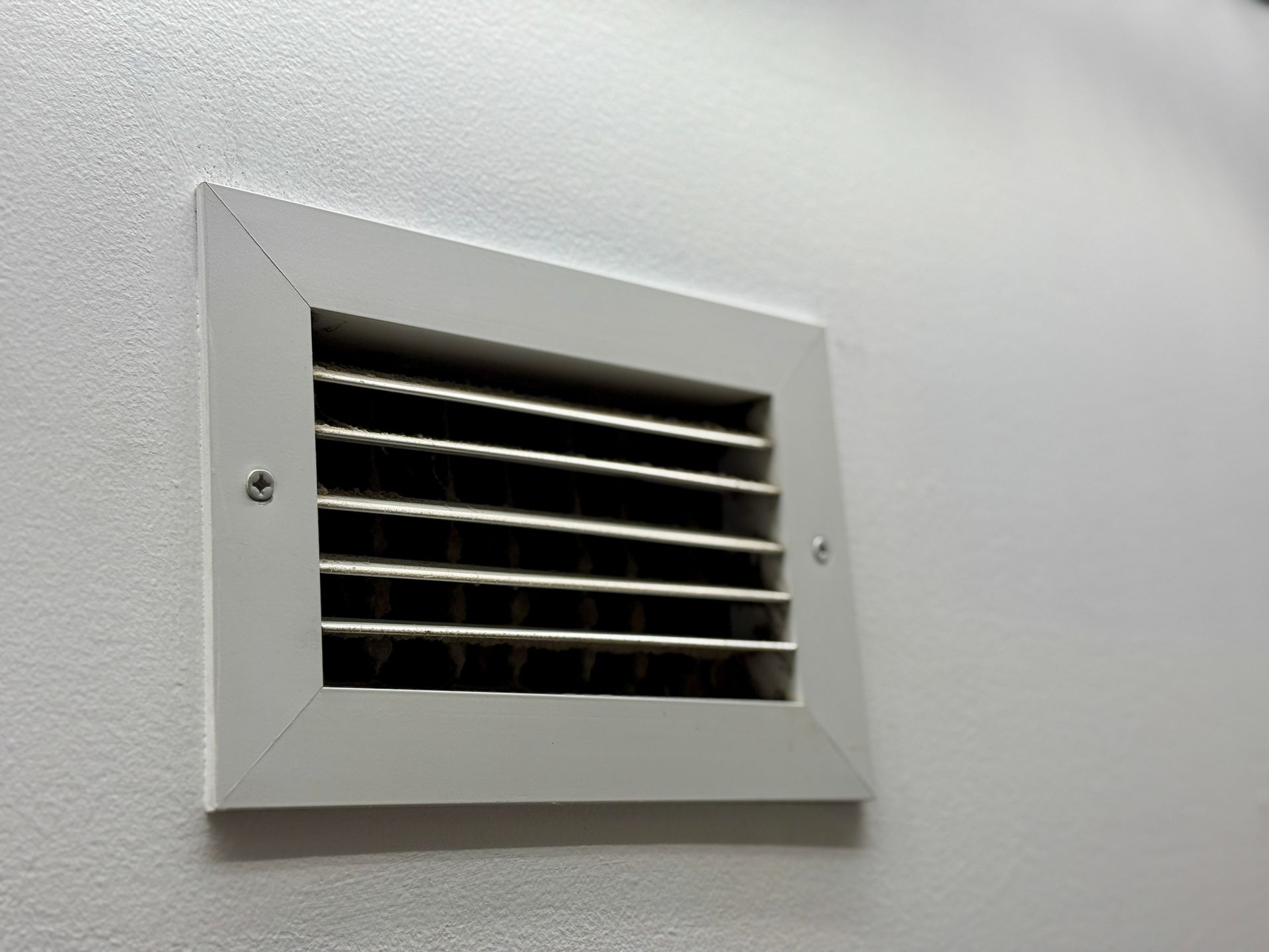Close-up of an air vent showing the need for a clean furnace filter.