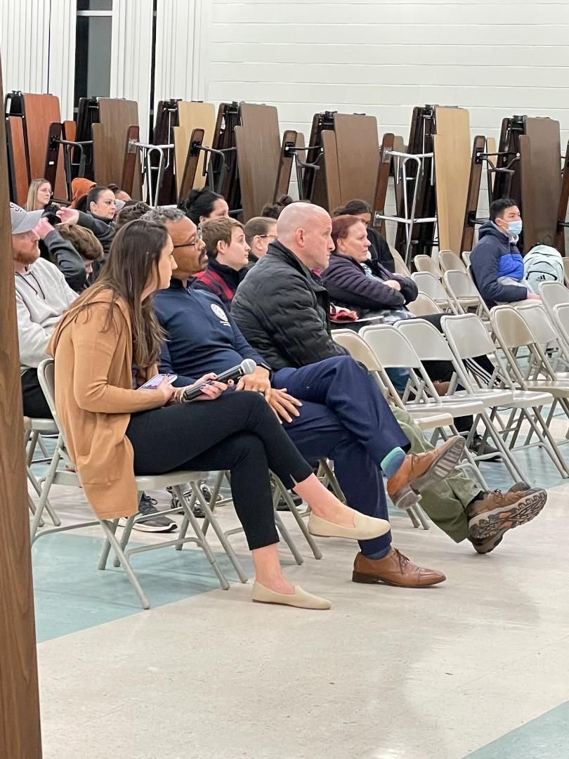 A group of people are sitting in chairs in a room.