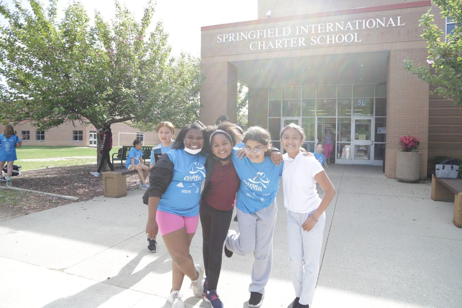 A group of children pose in front of the springfield international charter school
