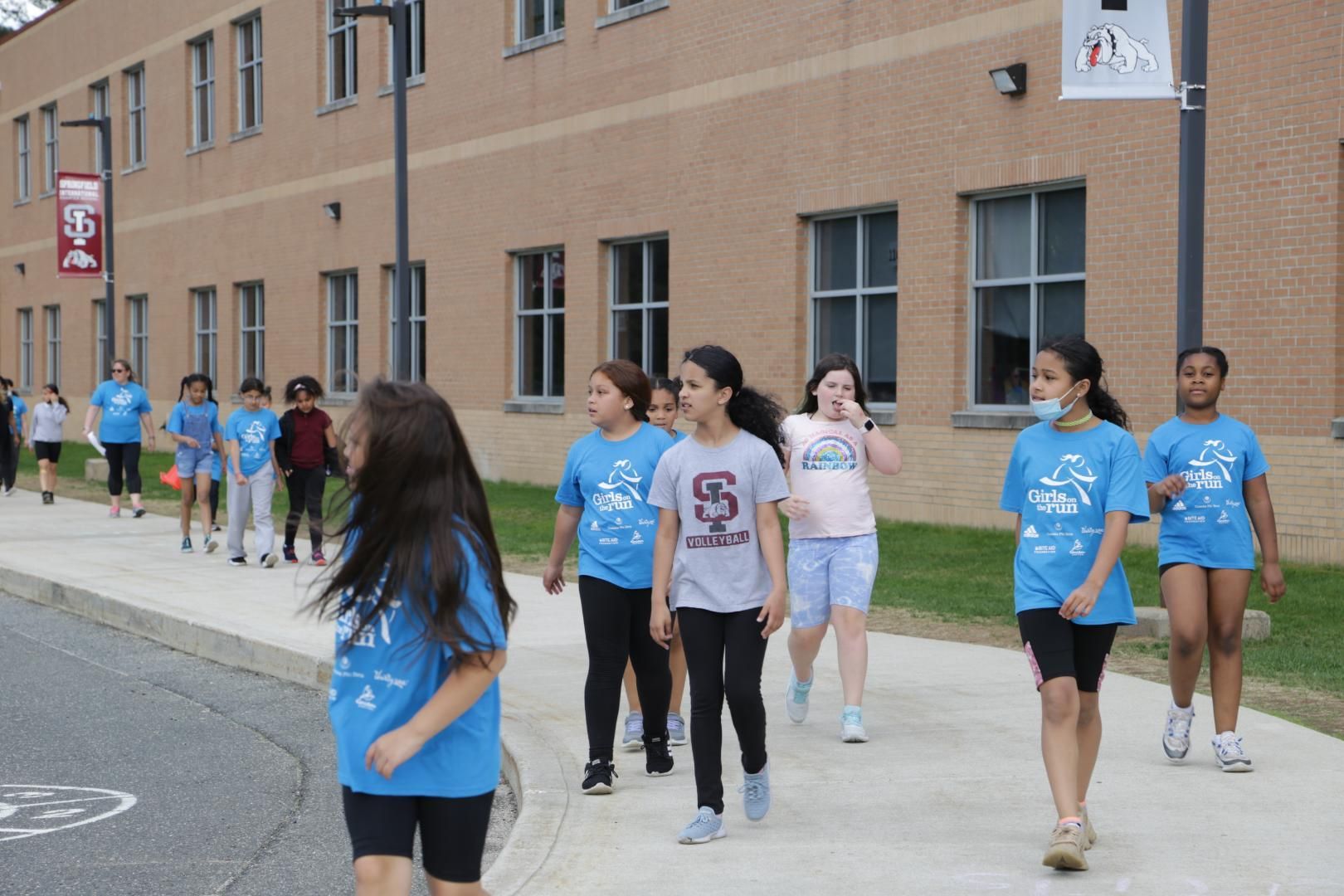 A group of children wearing blue shirts with the letter s on them