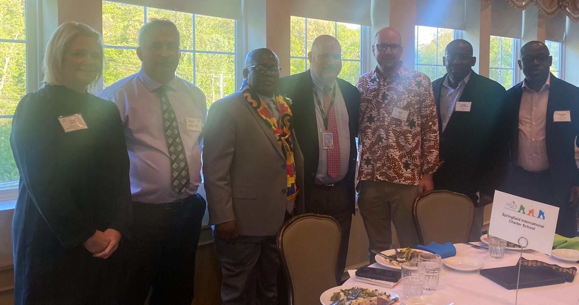 A group of people posing for a picture in front of a table
