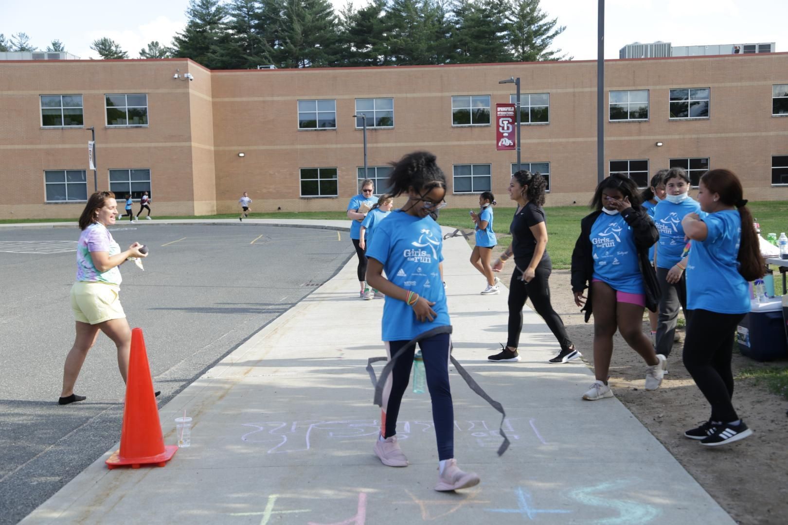 A group of people standing on a sidewalk in front of a building with the number 1 on it
