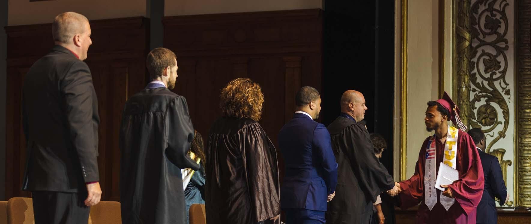 A group of people are standing around a woman in a graduation cap and gown.