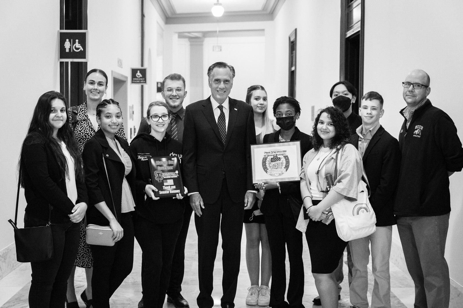 A group of people are posing for a picture in a hallway.