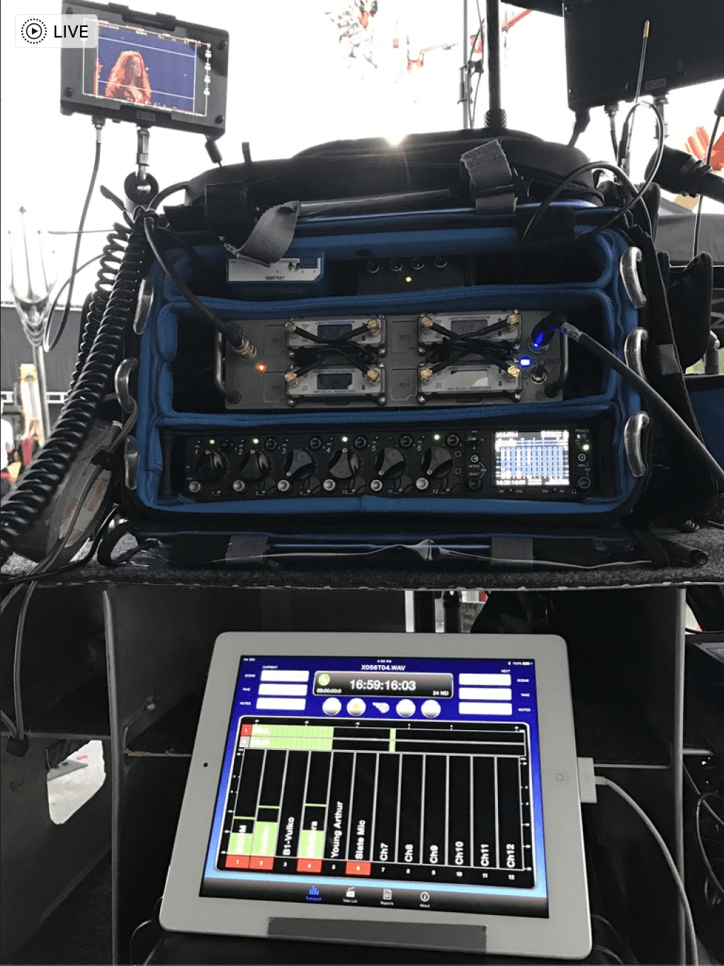 A mixer is sitting on top of a table next to a monitor.