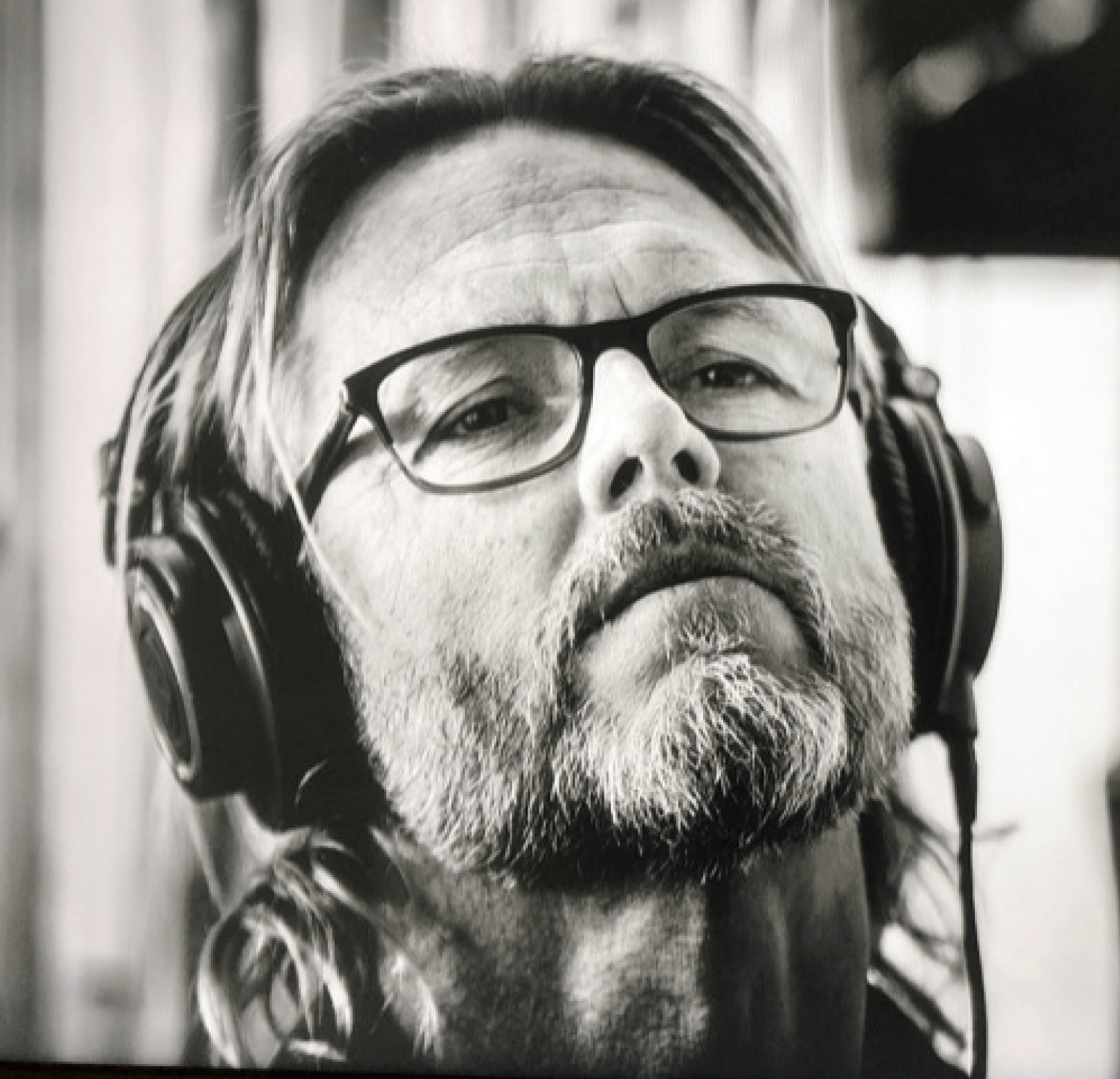 A man with glasses and a beard wearing headphones