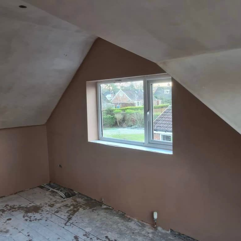 Interior room with freshly plastered walls, window, and exposed wooden floorboards.