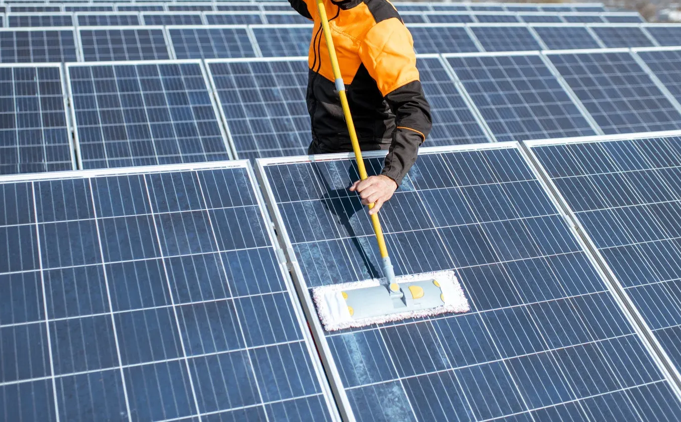 Elegant white kitchen with island, wooden beams, stainless steel appliances, and hardwood floors.