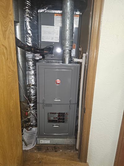 Gray Rheem furnace in a closet.