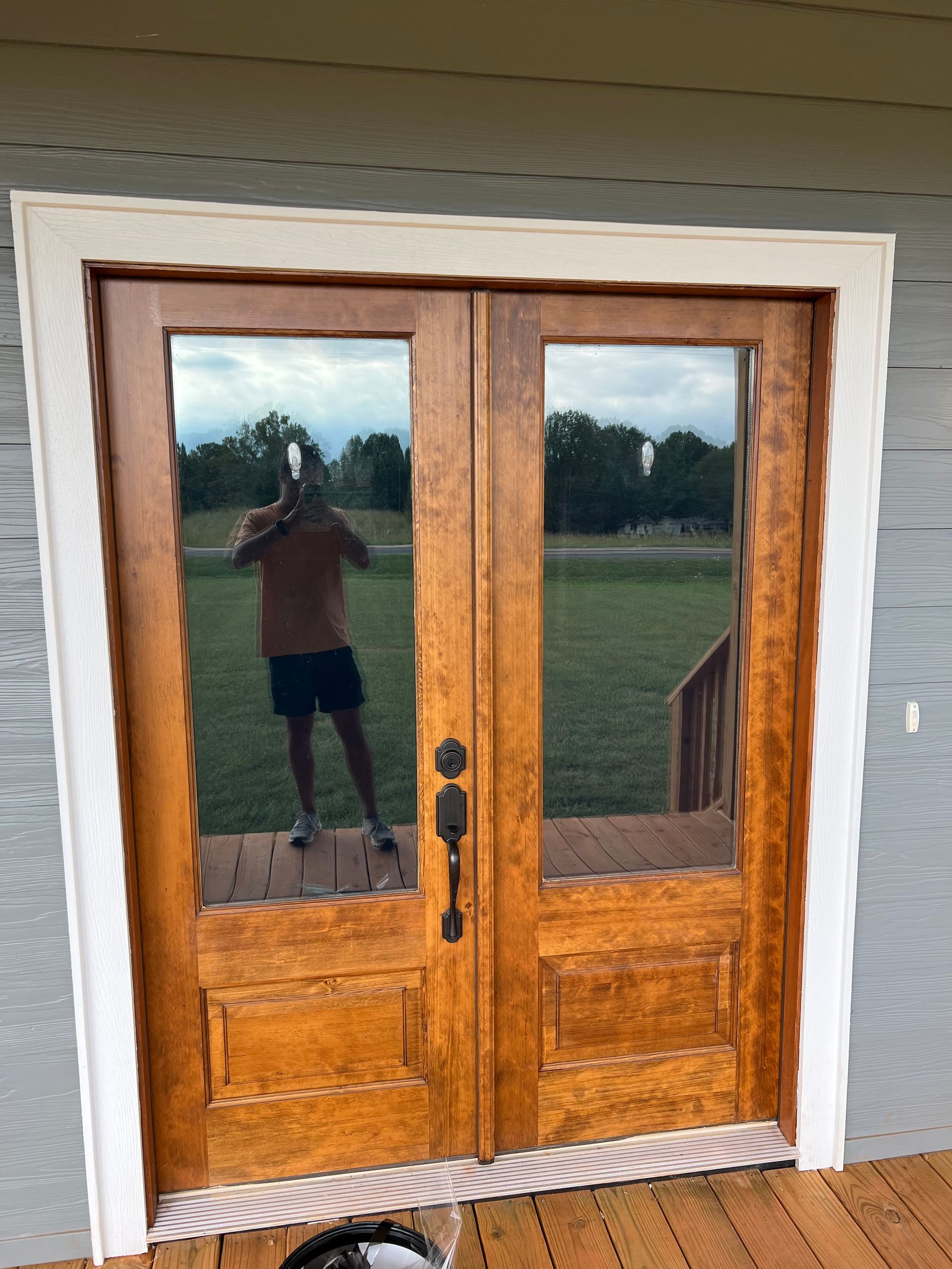 A man is taking a picture of himself in the mirror of a door.