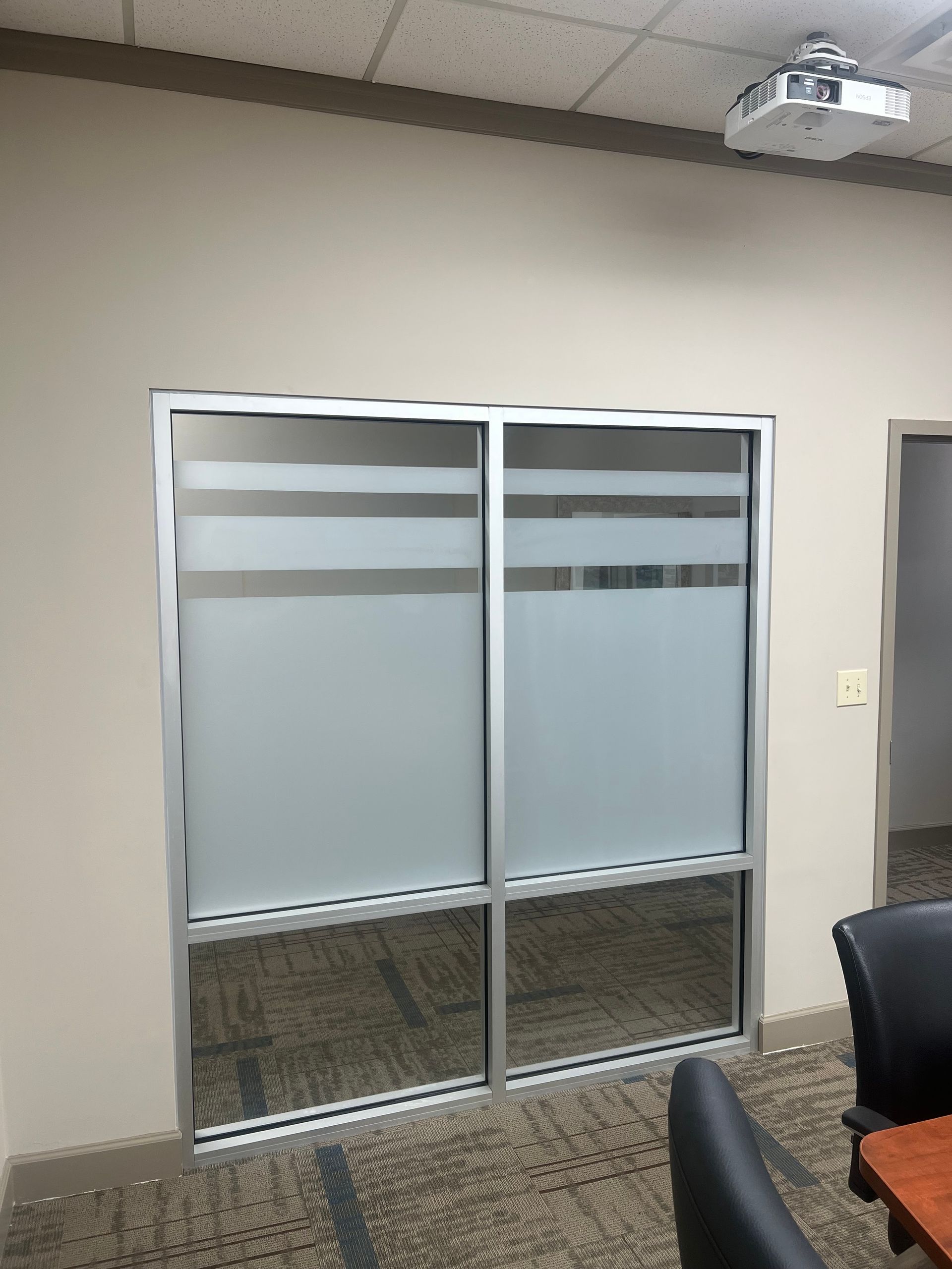 A conference room with sliding glass doors and a projector.