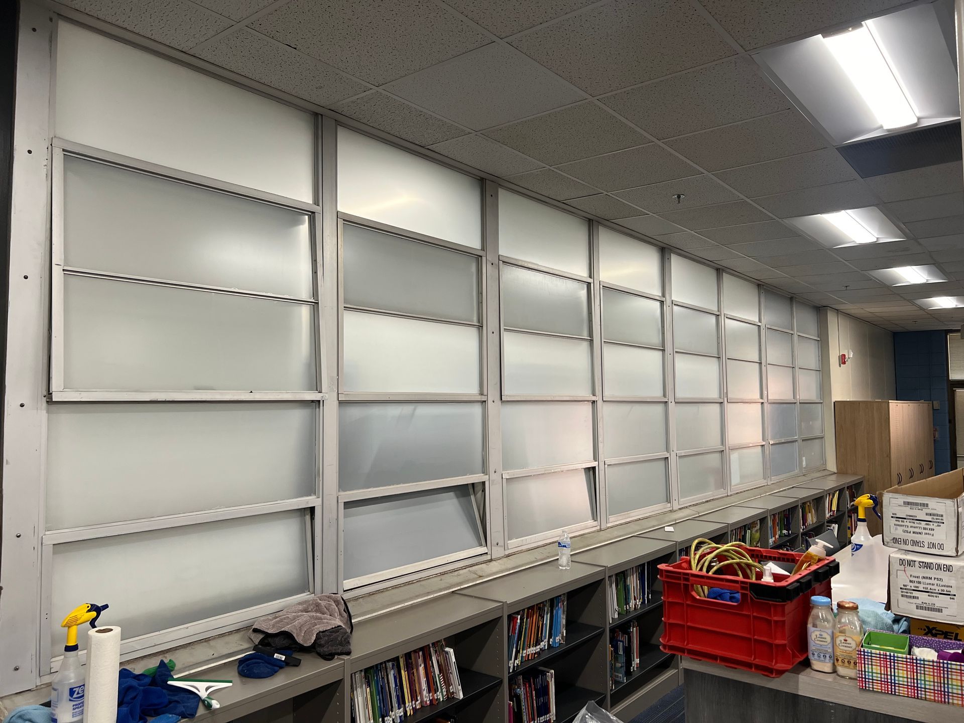 A room with a lot of shelves and a red basket on the floor