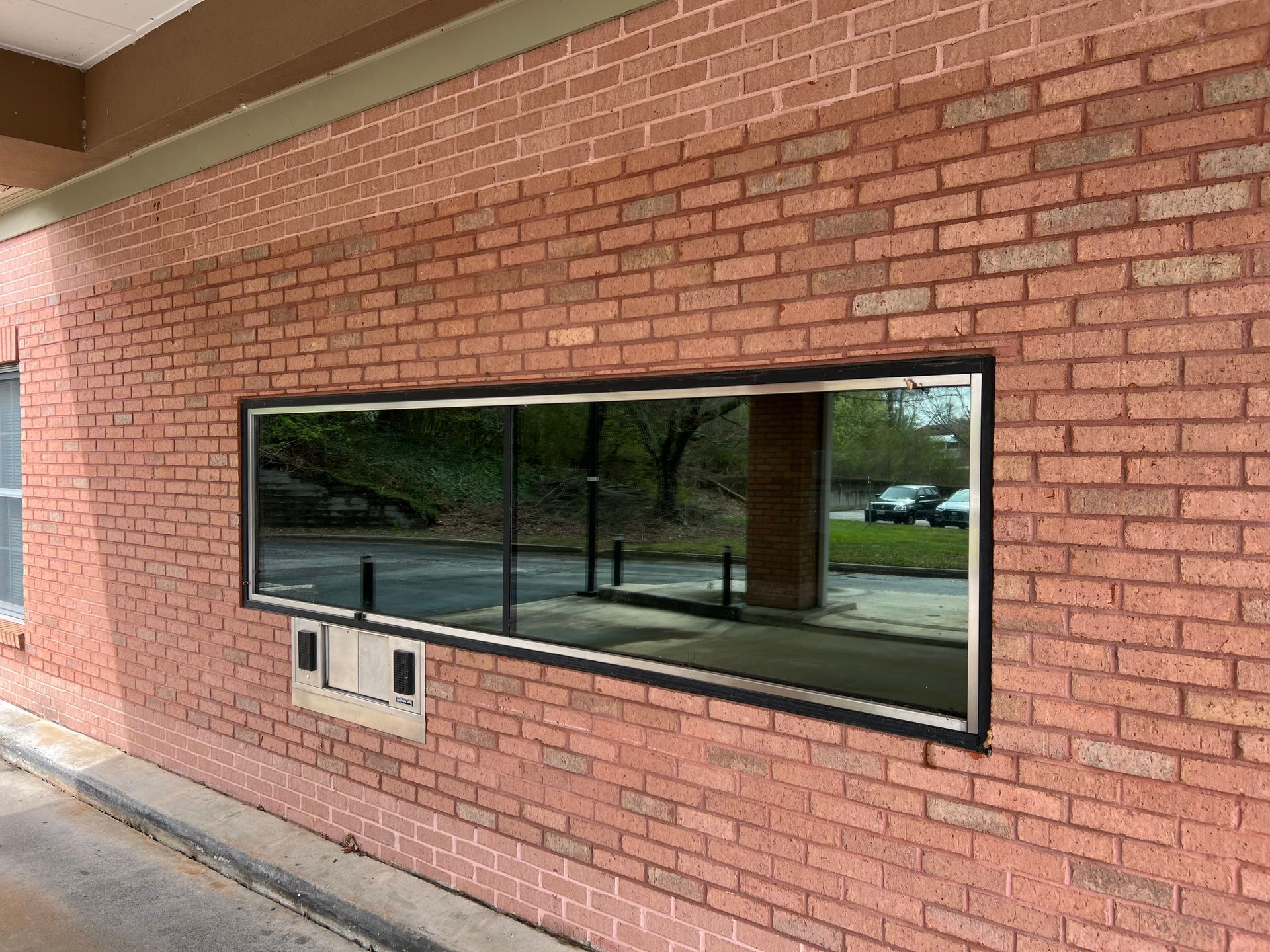 There is a large window on the side of a brick building.
