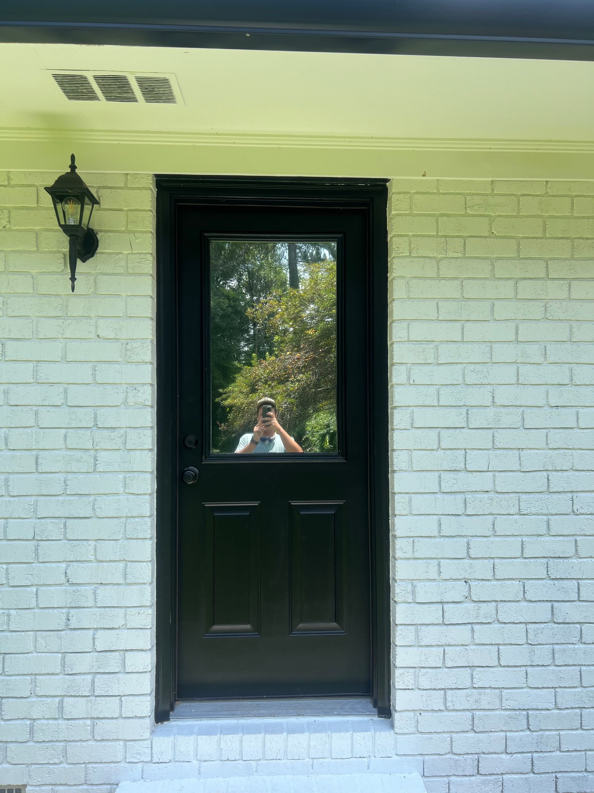 A white brick building with a black door