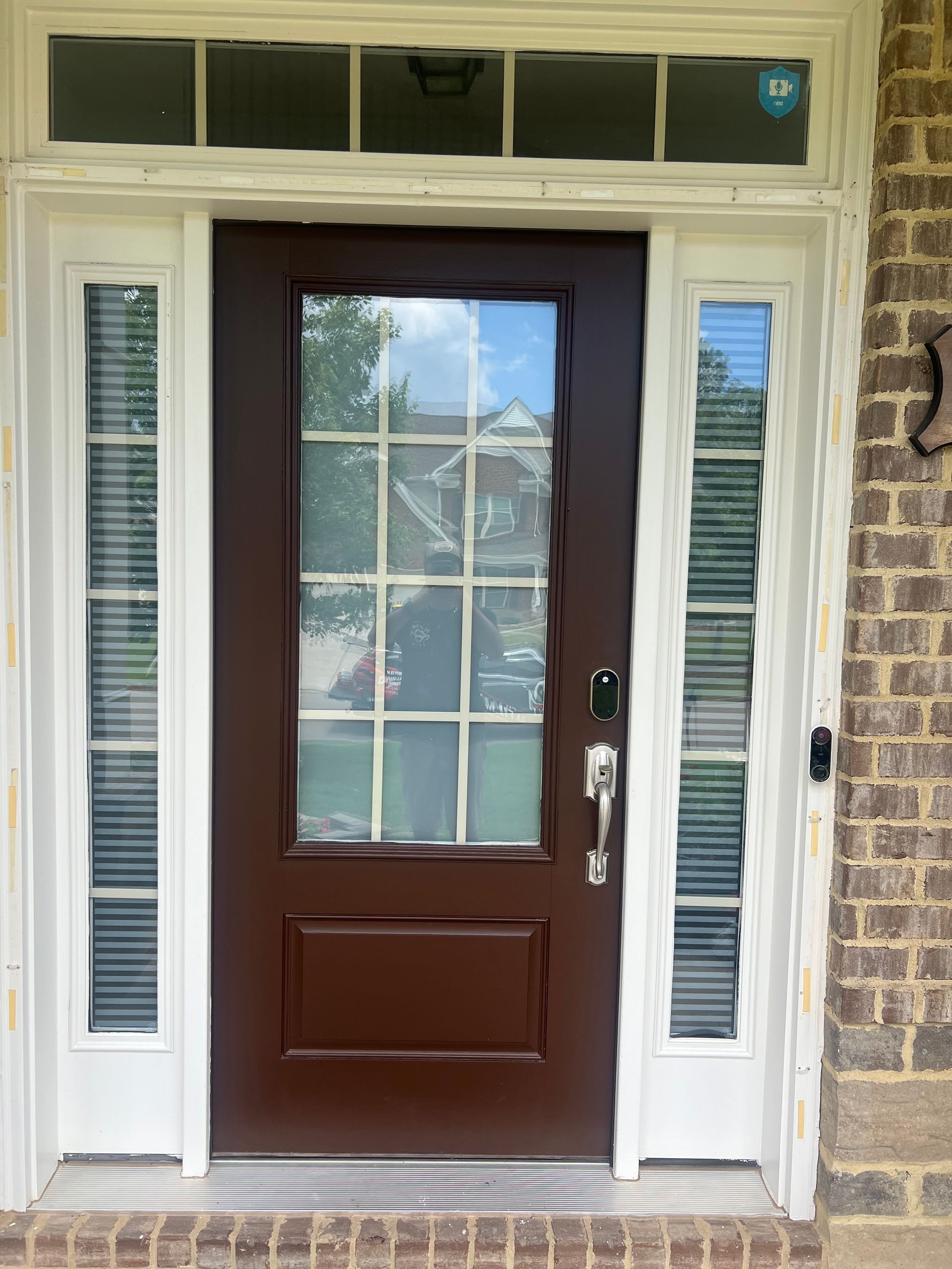 A brown door with a white trim is on a brick building